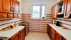 a kitchen with wooden cabinets and a window at Penthouse Mały Belweder in Ustrzyki Dolne