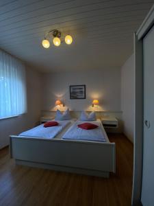 una camera da letto con un grande letto con due cuscini rossi di Haus Ohio Garni a Borkum