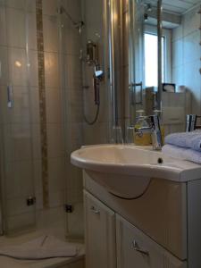 ein Bad mit einem Waschbecken und einer Dusche in der Unterkunft Haus Ohio Garni in Borkum