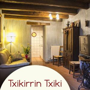 Casa rural Txikirrin Txiki - Selva de Irati في Villanueva de Aézcoa: غرفة معيشة مع أريكة وتلفزيون