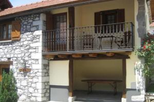 einen Balkon an der Seite eines Gebäudes mit einer Bank in der Unterkunft Casa rural Txikirrin Txiki - Selva de Irati in Villanueva de Aézcoa