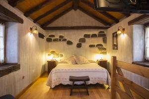 Casa rural Txikirrin Txiki - Selva de Irati في Villanueva de Aézcoa: غرفة نوم بسرير مع مصباحين وطاولتين