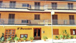 un edificio in mattoni gialli con balconi e piante di Albergo Grumentum a Grumento Nova