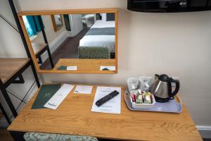 a table in a hotel room with a mirror at Bell Hotel by Greene King Inns in Tewkesbury