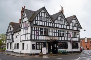 un edificio bianco e nero all'angolo di una strada di Bell Hotel by Greene King Inns a Tewkesbury