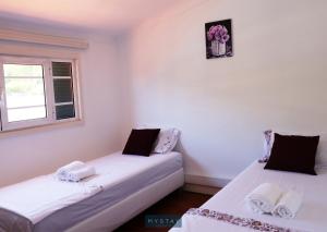 two beds in a room with a window at MyStay - Lira's Guest House in Porto
