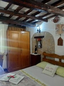 1 dormitorio con 1 cama y armario de madera en B&B Bellavista, en Bagnoregio