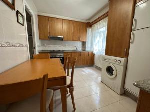 cocina con mesa, lavadora y secadora en Oktheway Praza de España en A Coruña