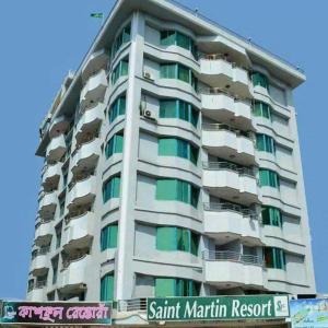 un grand immeuble d'appartements avec balcon et panneau de la rue dans l'établissement Saint Martin Resort, à Cox's Bazar
