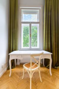 a white table and a chair in front of a window at Large Luxury Residence Near Townhall & Votivkirche in Vienna