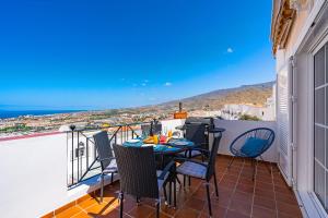 d'une terrasse avec une table et des chaises sur un balcon. dans l'établissement BuenaVista Bellarosa Sunset Ocean View in Costa Adeje with airco, garage, à Adeje