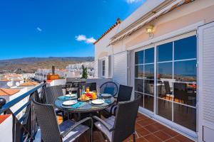 d'une terrasse avec une table et des chaises sur un balcon. dans l'établissement BuenaVista Bellarosa Sunset Ocean View in Costa Adeje with airco, garage, à Adeje