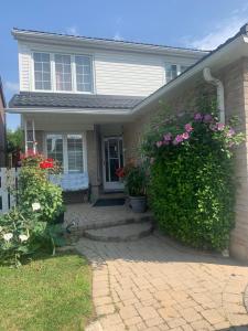 een huis met een heg met bloemen erop bij BIG Oasis Studio near Airport YYZ in Toronto
