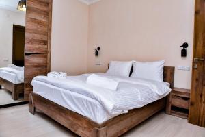 ein Schlafzimmer mit einem großen Bett mit weißer Bettwäsche in der Unterkunft Maestro Rest House Dilijan in Dilidschan