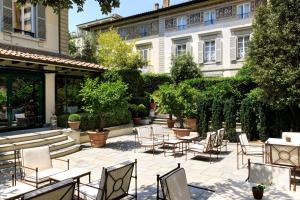 a patio with tables and chairs in front of a building at Hotel Regency - Small Luxury Hotels of the World in Florence