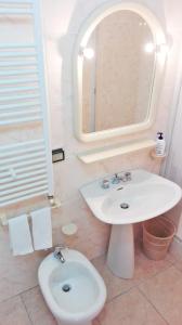 un bagno con lavandino, water e specchio di Albergo Grumentum a Grumento Nova