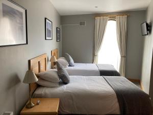 a hotel room with two beds and a window at The Sleepwell Inn in Workington