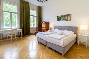 ein Schlafzimmer mit einem großen Bett und zwei Fenstern in der Unterkunft Large Luxury Residence Near Townhall & Votivkirche in Wien