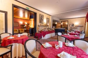 a restaurant with tables and chairs with red table cloth at Hotel Giardinetto in Desenzano del Garda