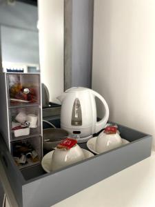 a refrigerator with a tea kettle and dishes in it at The White Horse Crostwick in Norwich