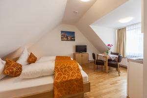 a hotel room with a bed and a desk with a television at Seehotel BelRiva in Hagnau