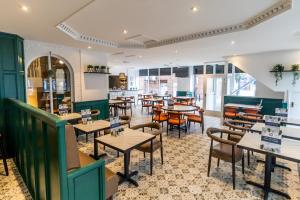 a restaurant with tables and chairs and a cafeteria at The Sleepwell Inn in Workington