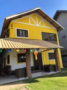 a yellow house with flags on the front of it at Casa em Bananeiras PB in Bananeiras