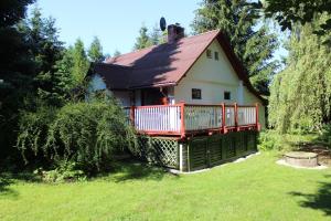 a small house with a deck on a yard at Niezapominajka in Bystrzyca Kłodzka