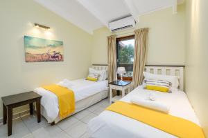 a bedroom with two beds and a window at San Lameer Villa 3014 - 3 Bedroom Classic - 6 pax - San Lameer Rental Agency in Southbroom +41 photos