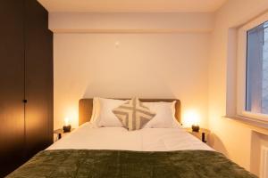 1 dormitorio con 1 cama con sábanas blancas y ventana en Luxe appartement met frontaal zeezicht bij Casino, en Ostende