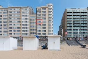 un grupo de edificios en una playa de arena con edificios en Luxe appartement met frontaal zeezicht bij Casino, en Ostende