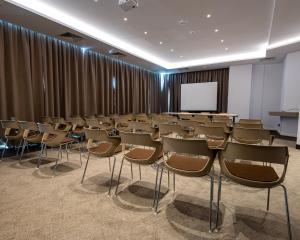 una sala conferenze con sedie e schermo di HOTEL NOVA LUXURY a Târgovişte