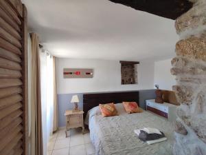 a bedroom with a bed and a stone wall at Résidence A CASA VECCHIA gites de charme avec JACUZZI proche Ajaccio in Peri