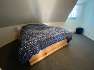 a bedroom with a bed with a blanket on it at Logement au Cœur du Village in Saint-Jean-Port-Joli