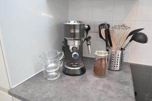 a kitchen counter with a coffee maker and a glass at Cowes Town House in Cowes