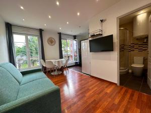 a living room with a couch and a tv and a table at Résidence 4T - 33 bis Avenue Gaston Chauvin in Aulnay-sous-Bois