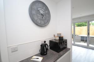 eine Uhr, die in einer Küche an einer Wand hängt in der Unterkunft Town House in Cowes in Cowes