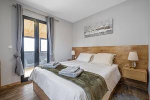 sypialnia z dużym białym łóżkiem i oknem w obiekcie Salsa Country House II by Madeira Sun Travel w mieście Porto Moniz