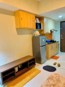 a kitchen with a stainless steel refrigerator and wooden cabinets at Cozynest Condotel Baguio in Baguio