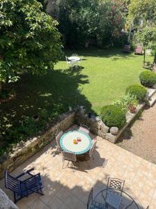 patio con mesa y sillas en Appartement avec accès piscine et jardin dans hôtel particulier, en Nérac