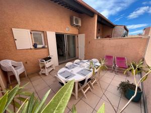 a patio with a table and chairs on a house at Charmant pavillon pour 5-6 pers. in Cap d'Agde