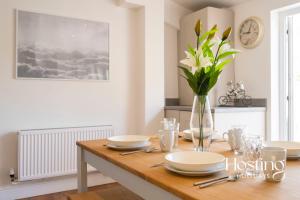 een eettafel met een vaas met bloemen erop bij Cosy Countryside Cottage With Incredible Views in Henley on Thames