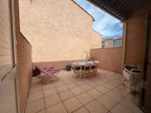 a patio with a table and chairs on a balcony at Charmant pavillon pour 5-6 pers. in Cap d'Agde