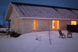 a house with two chairs in the snow at Charming villa with a hot tub, by the Golden Circle in Reykholt