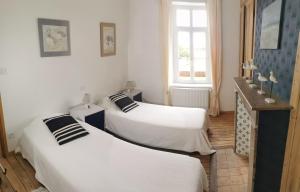 two beds in a room with white walls and a window at Le Clos du Hesdre in Neufchâtel-Hardelot
