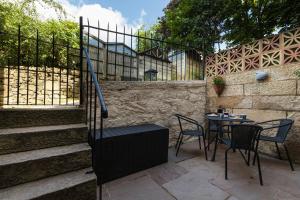 a patio with a table and chairs and a fence at Hygge House in Matlock