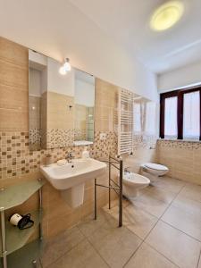 y baño con lavabo y aseo. en La Chiostrina by TraMonti Apartments en LʼAquila