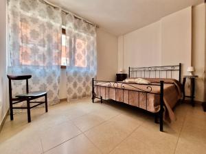een slaapkamer met een bed en een stoel bij La Chiostrina by TraMonti Apartments in LʼAquila