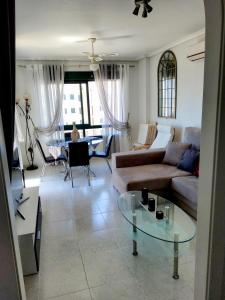 sala de estar con sofá y mesa de cristal en Superbe appartement calme vue mer, en Orihuela Costa