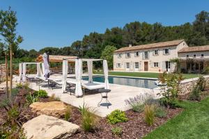 une terrasse avec des chaises et une piscine en face d'une maison dans l'établissement Mas de Lure, à Salon-de-Provence